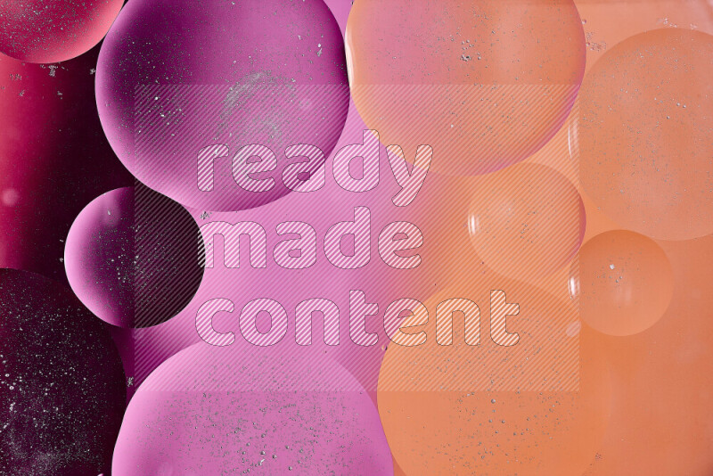 Close-ups of abstract oil bubbles on water surface in shades of red, orange and pink