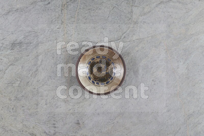 A decorative pottery plate on grey marble background