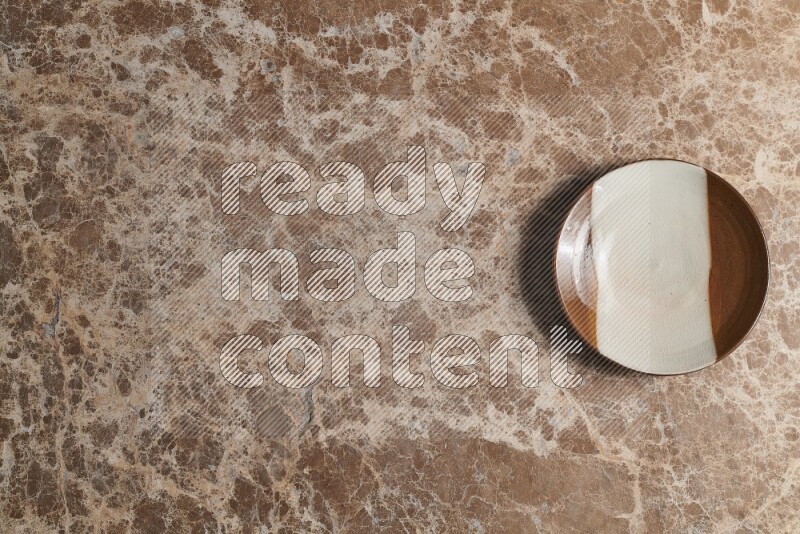 A decorative pottery plate on beige marble background