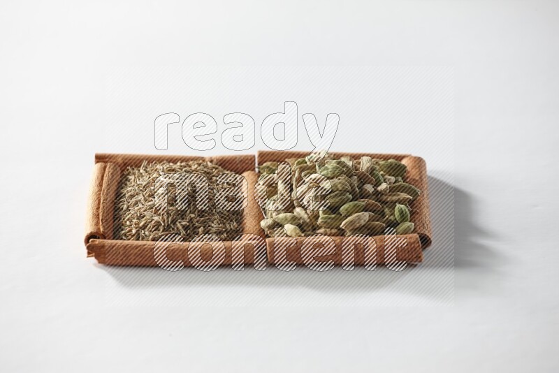 2 squares of cinnamon sticks full of cardamom and cumin on white flooring