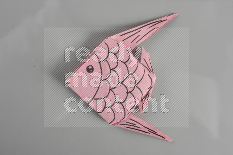 Origami fish on grey background