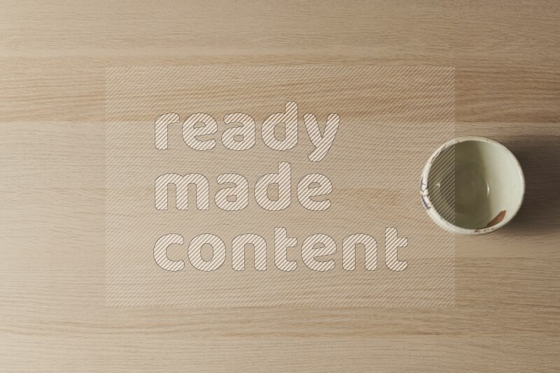 A white pottery bowl on light wooden background