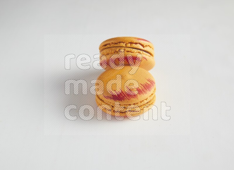 45º Shot of two orange Exotic macarons on white background