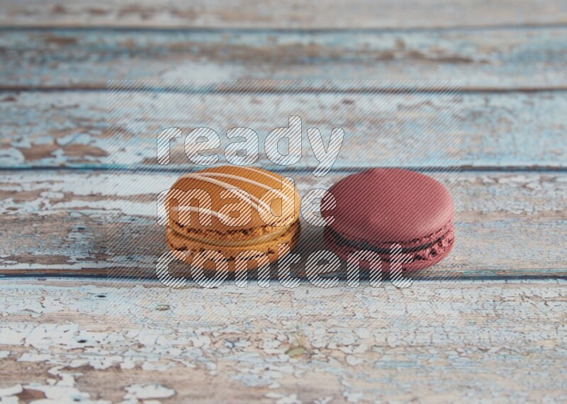 45º Shot of of two assorted Brown Irish Cream, and Red Cherry macarons  on light blue background
