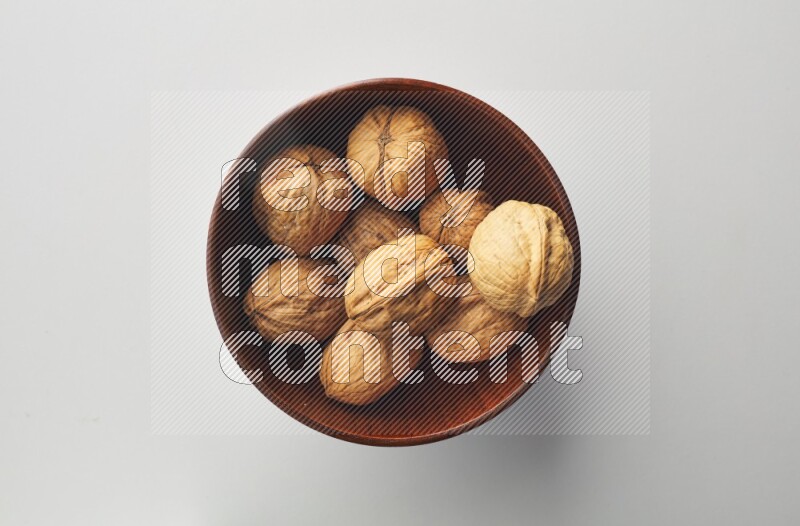 Top-view shot of walnut in a container on white background