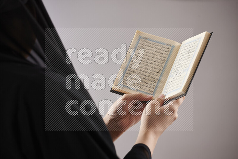 امرأة تحمل بيديها مصحف القرآن في أوضاع متعددة