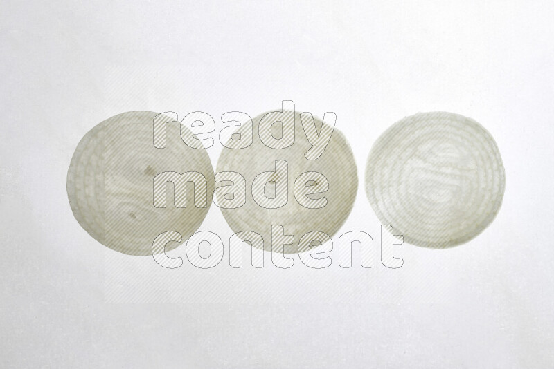 Onion slices on illuminated white background
