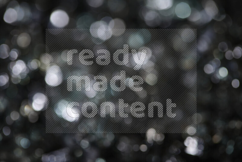 Transparent black fragments of glass scattered on a black background