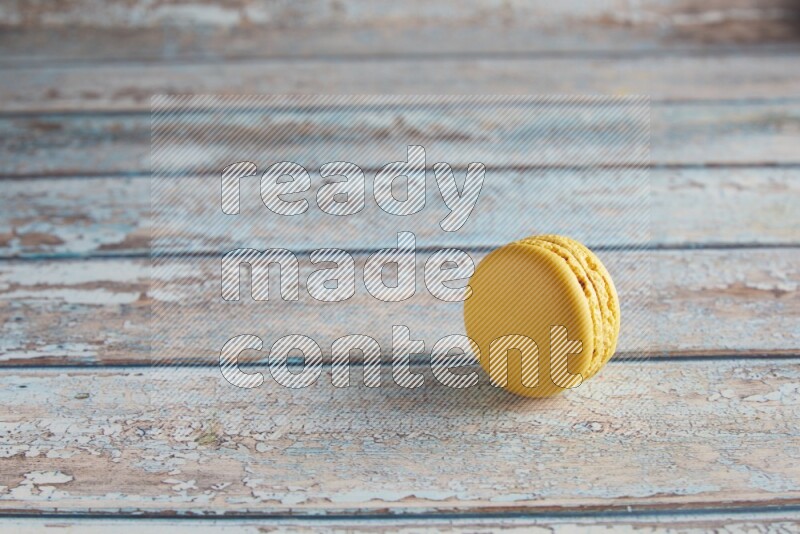 45º Shot of Yellow Lemon macaron on light blue wooden background