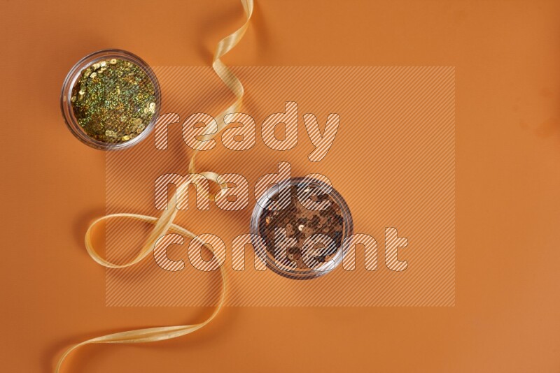 A yellow collection of sewing and tailoring tools arranged on a orange background
