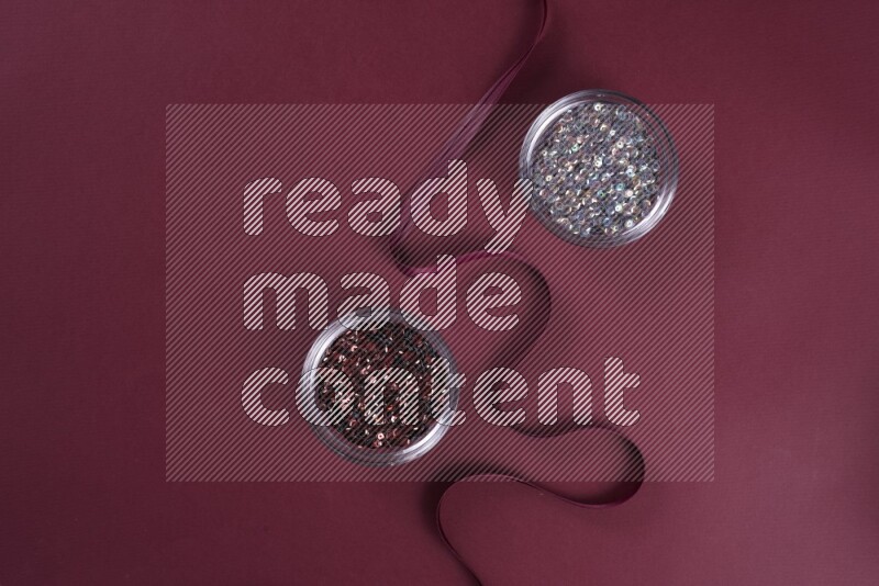 A grey collection of sewing and tailoring tools arranged on a red background