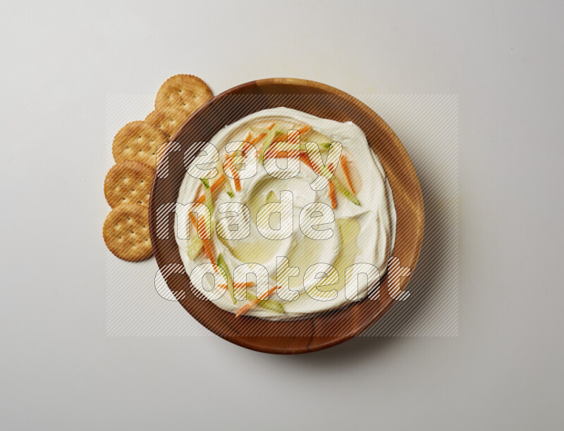 Lebnah garnished with sliced carrots & cucumber in a wooden plate on a white background