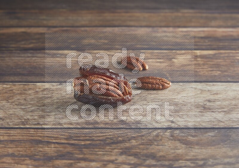 pecan stuffed madjoul date on a wooden background