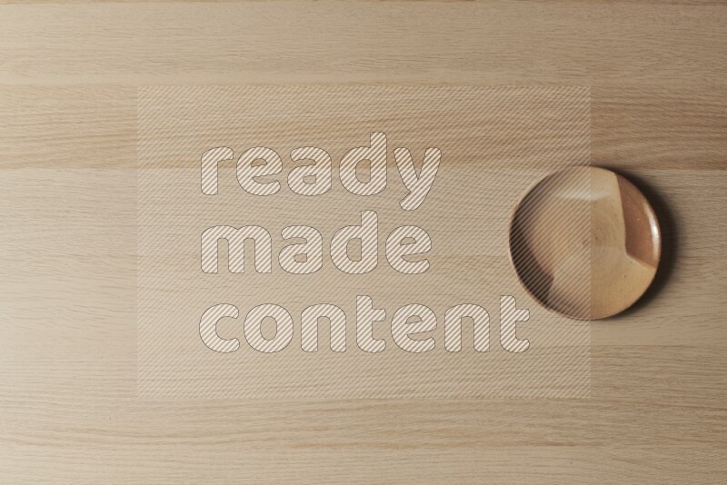 A multicolored pottery plate on light wooden background
