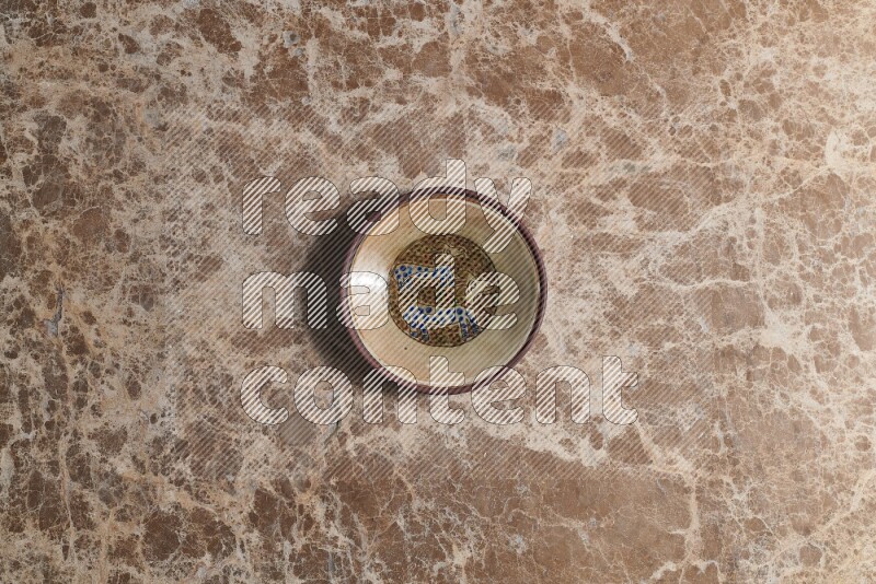 A decorative pottery plate on beige marble background