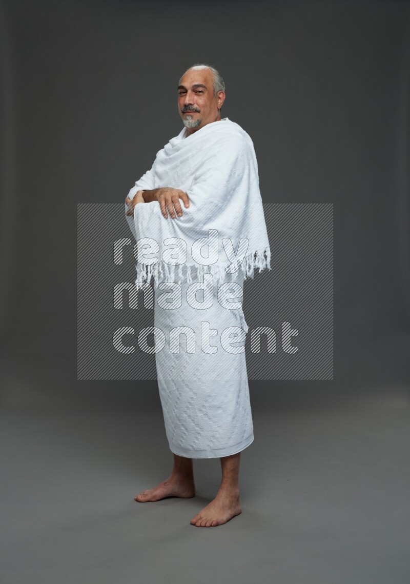 A man wearing Ehram Standing Interacting with the camera on gray background
