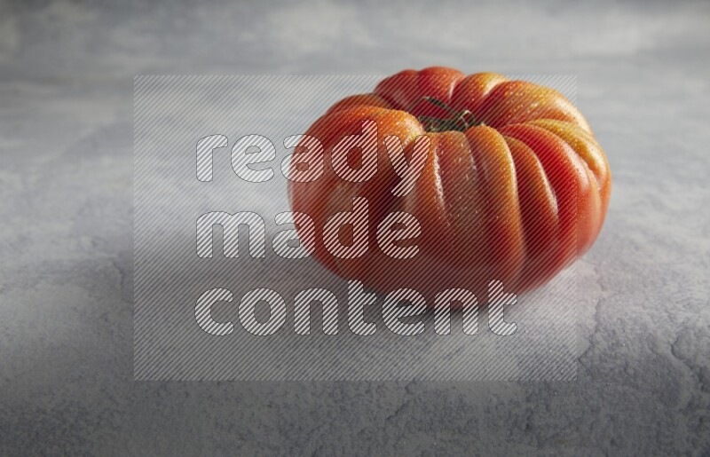 45 degree single heirloom tomato on a light blue textured background