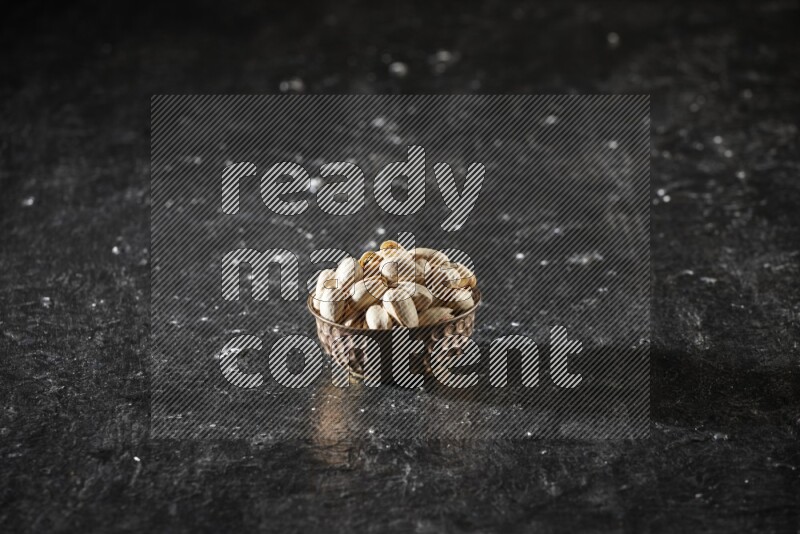 مكسرات في وعاء معدني علي خلفية سوداء