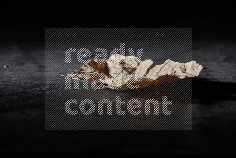 مسحوق الفلفل الأبيض في قطعة من الورق على أرضية سوداء