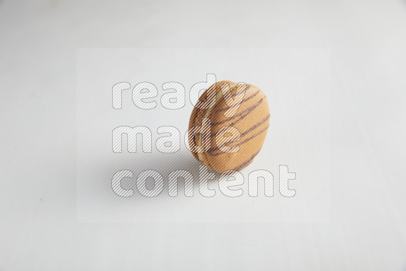 45º Shot of light brown  Almond Cream macaron on white background