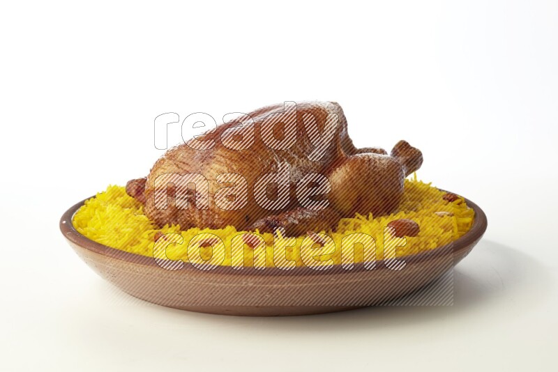 yellow basmati Rice with whole roasted chicken  on a pottery plate  direct  on white background