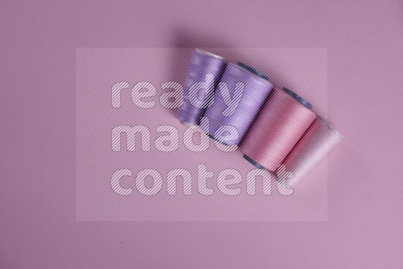 مجموعة من أدوات الخياطة والتفصيل أرجوانية وزهرية اللون على خلفية زهرية