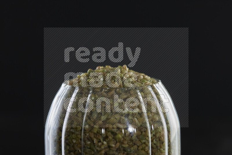Freekeh in a glass jar on black background
