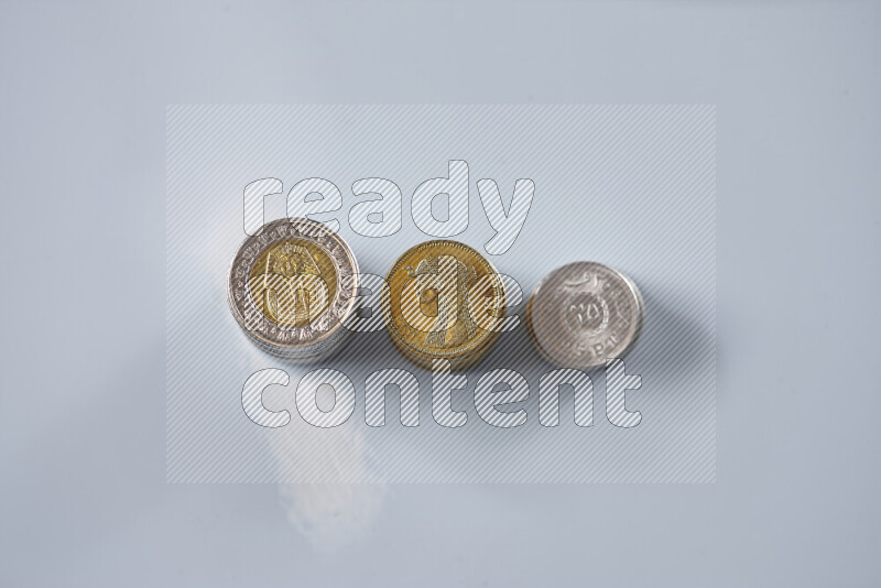 A close-up of scattered mixed Egyptian coins such as One pound, 50 and 25 piasters on grey background