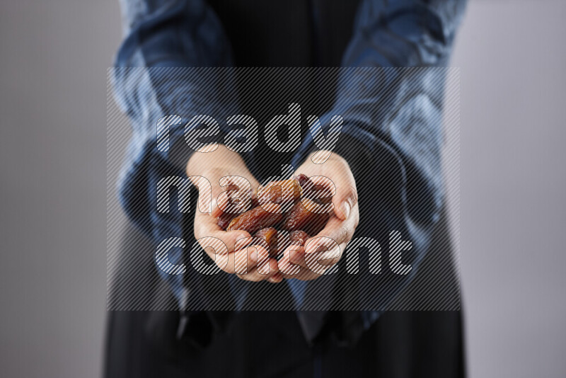 Woman in abaya holding dates in different positions