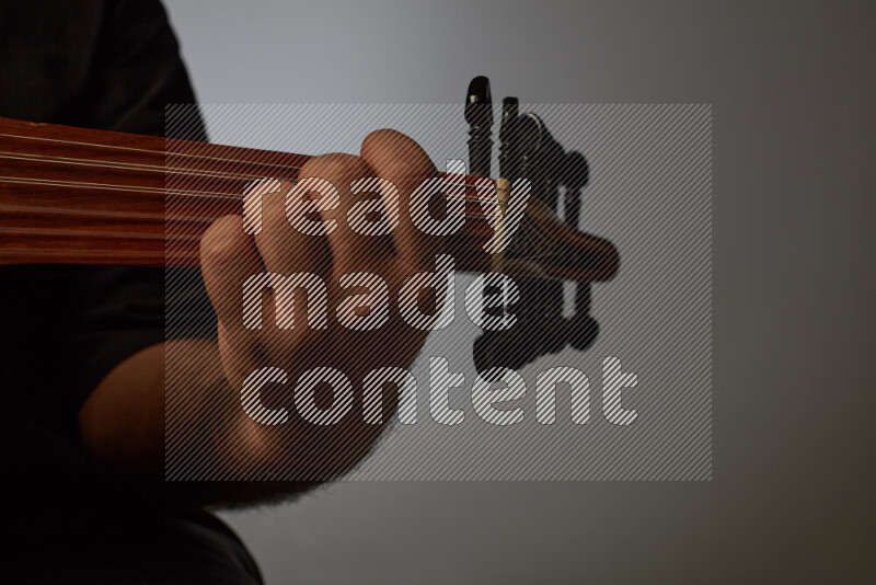 يد رجل تعزف على عود خشبي بني