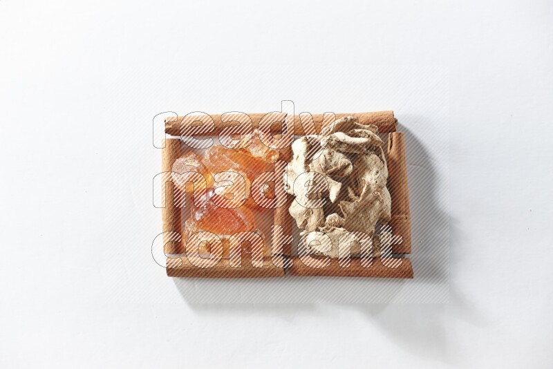 2 squares of cinnamon sticks full of dried ginger and gum arabic on white flooring