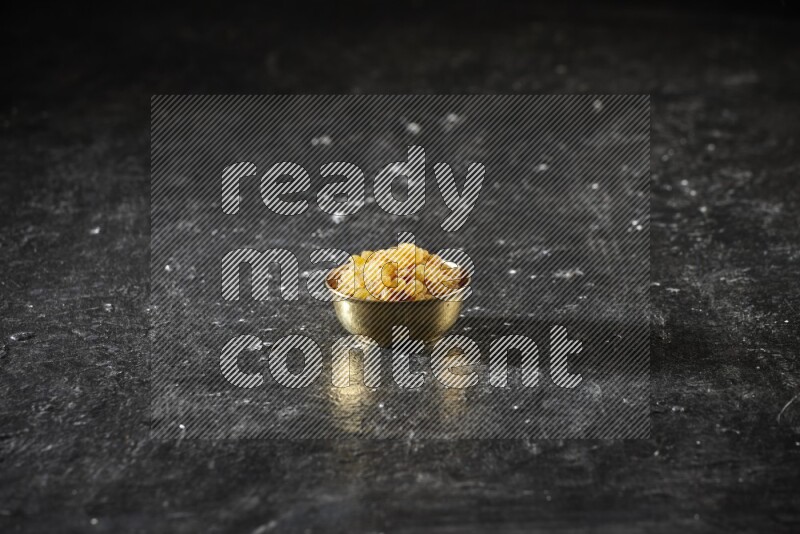 فواكه مجففة في وعاء معدني علي خلفية سوداء