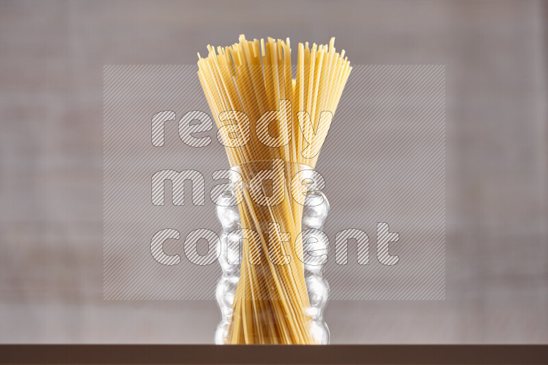 Raw pasta in glass jars on beige background