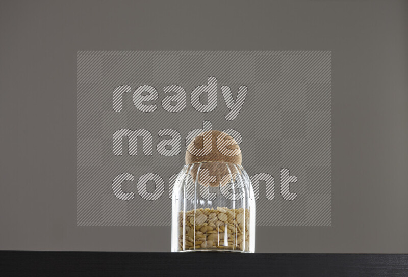 Crushed beans in a glass jar on black background