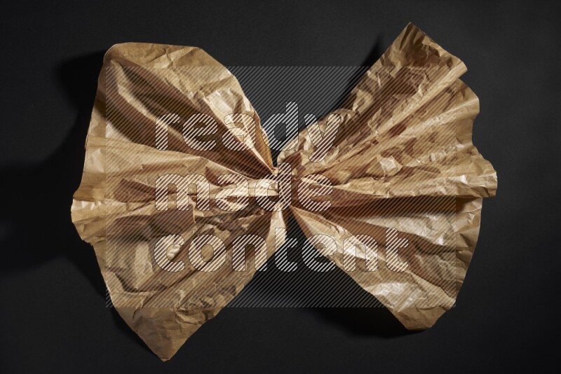 Crumpled craft paper on black background