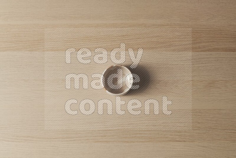 A multicolored pottery bowl on light wooden background