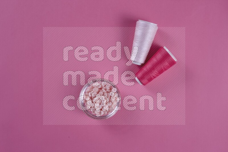 مجموعة من أدوات الخياطة والتفصيل زهرية اللون على خلفية زهرية