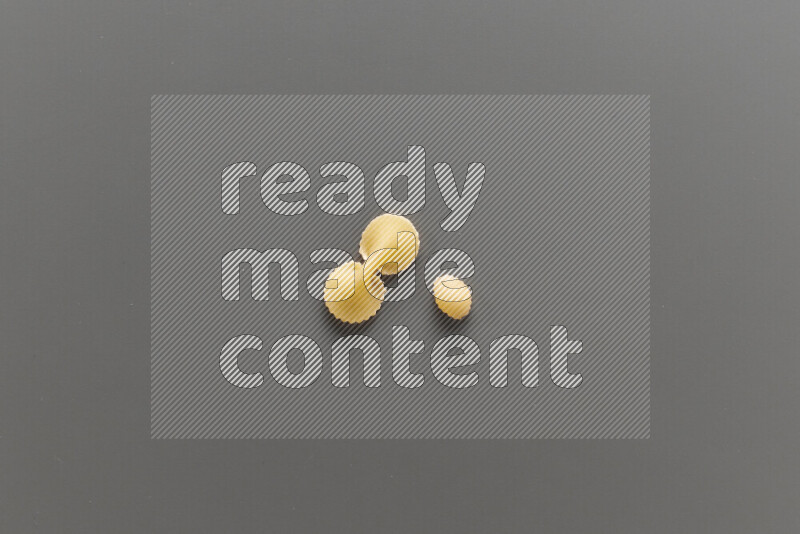 Fiocchi pasta with other types of pasta on grey background