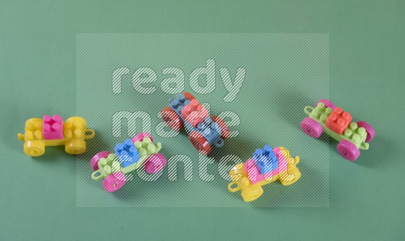 Little toy cars made of plastic on yellow and green background (kids toys)