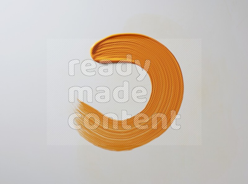 An orange circular painting brush stroke on white background
