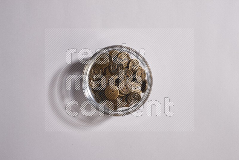 Colored buttons in a glass bowl on grey background