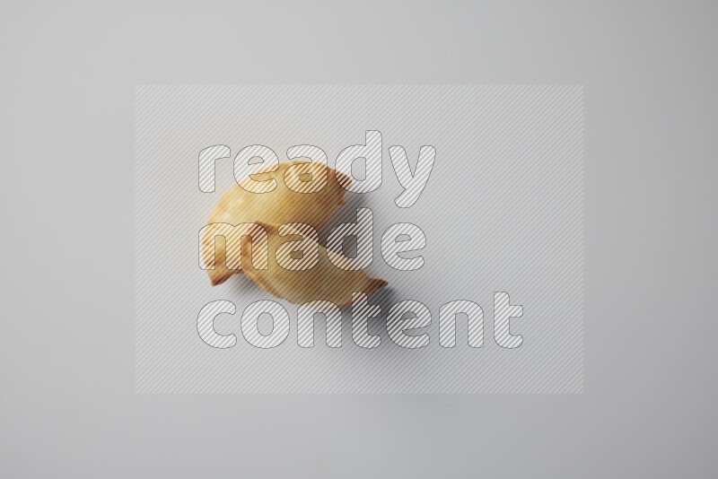 Two fried sambosa from a top angle on a white background