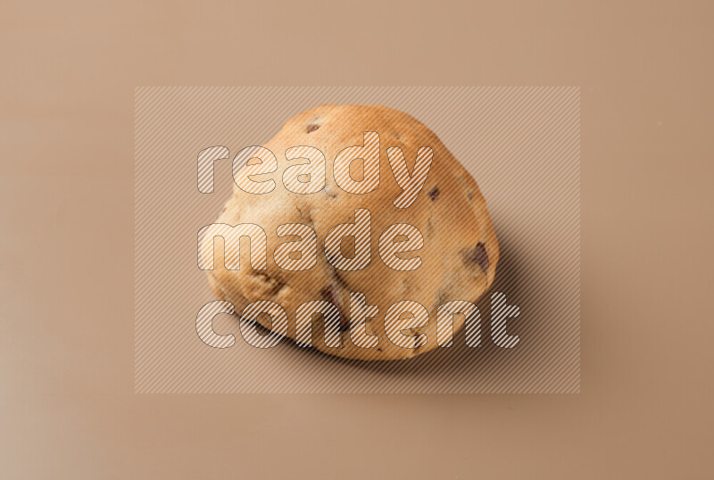 a whole chocolate chip cookie on a brown background