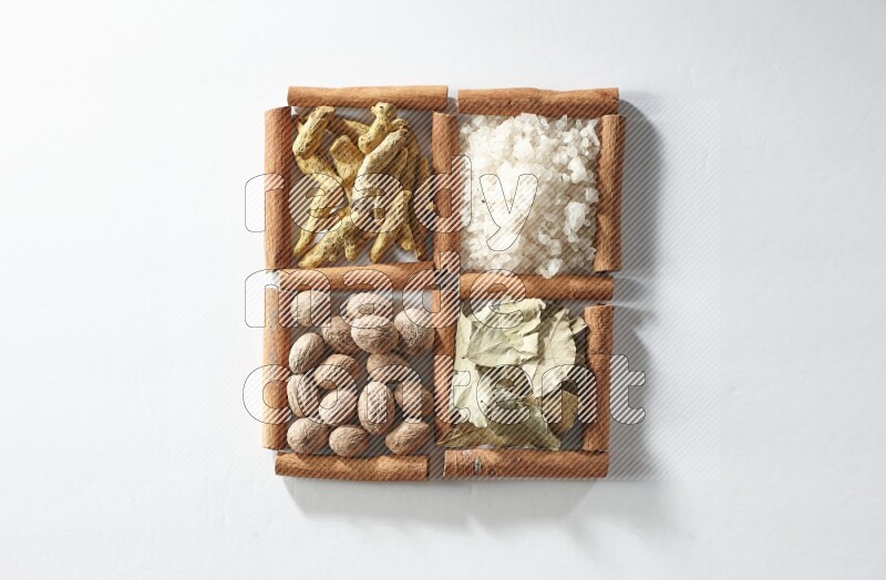4 squares of cinnamon sticks full of salt, bay laurel, nutmeg, turmeric on white flooring