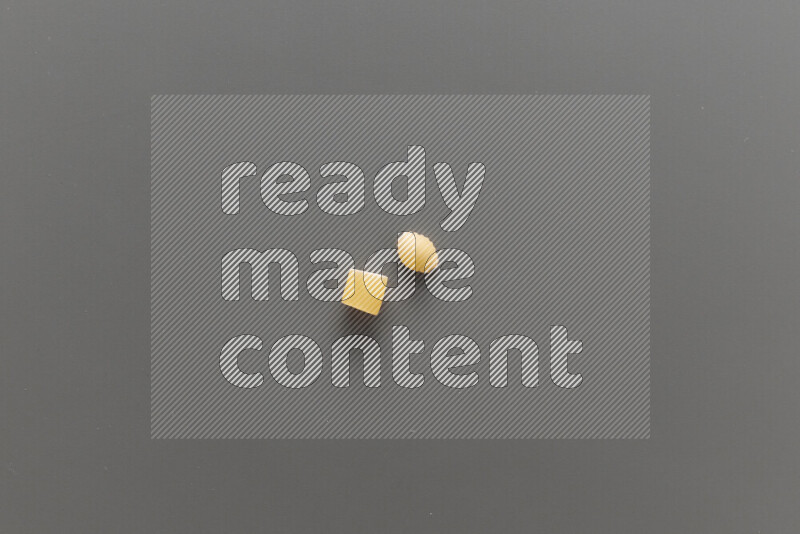Big rings pasta with other types of pasta on grey background