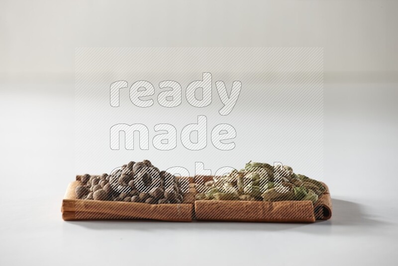 2 squares of cinnamon sticks full of cardamom and allspice on white flooring