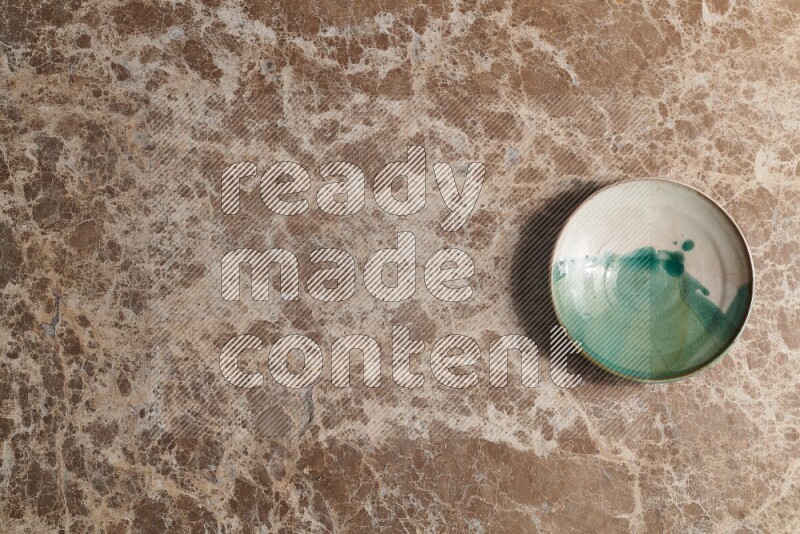 A decorative pottery plate on beige marble background