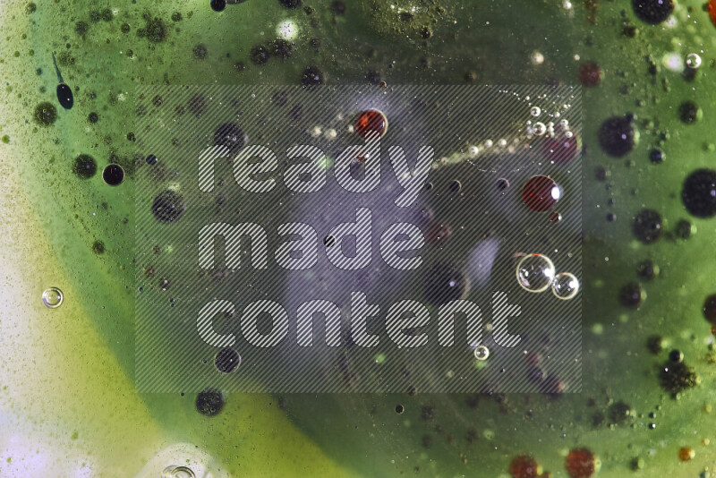 Close-ups of abstract red, green and blue watercolor drops on oil Surface on green background