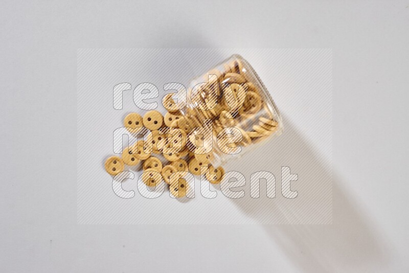 Colored buttons in a glass jar on grey background