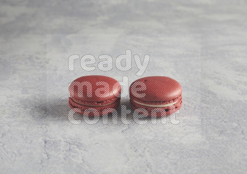 45º Shot of two Red Velvet macarons  on white  marble background